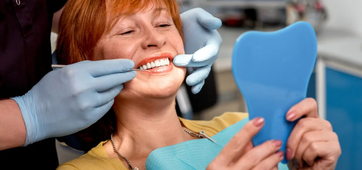 dentist showing a female patient her new smile, dental bridge restoration