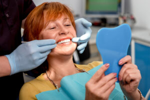 dentist showing a female patient her new smile, dental bridge restoration