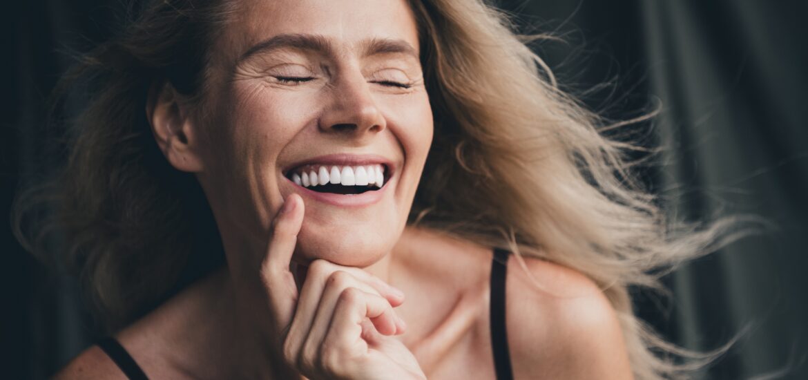 closeup of a blonde woman showing her perfect white smile