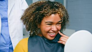 happy young woman smiling in a dental chair, bright white smile