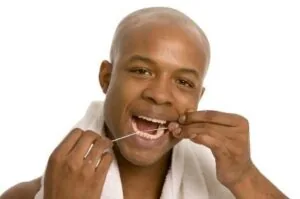 A man flossing to prevent gum disease in White Plains.